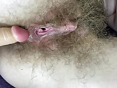 Fur covered girl tears up her moist meaty pearl twat with dildo in close up